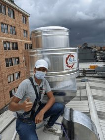 Trabajador instalando un equipo de ventilación en una azotea